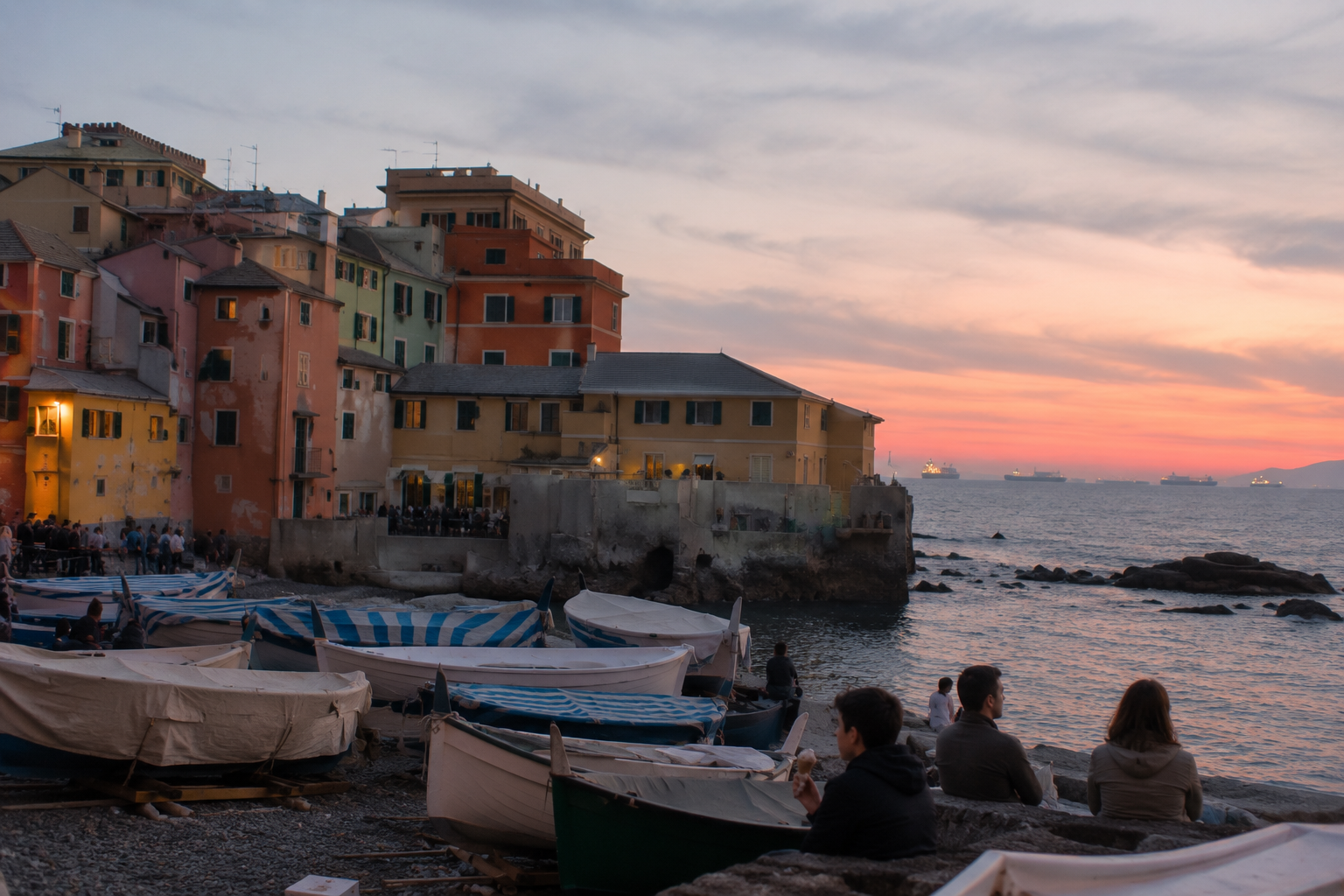 Boccadasse's colourful harbour with container ships on the horizon
