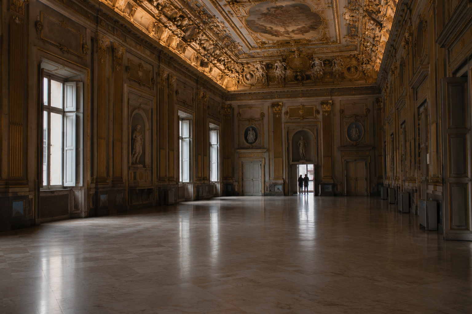 A frescoed hall inside one of the Rolli palaces, nearly empty